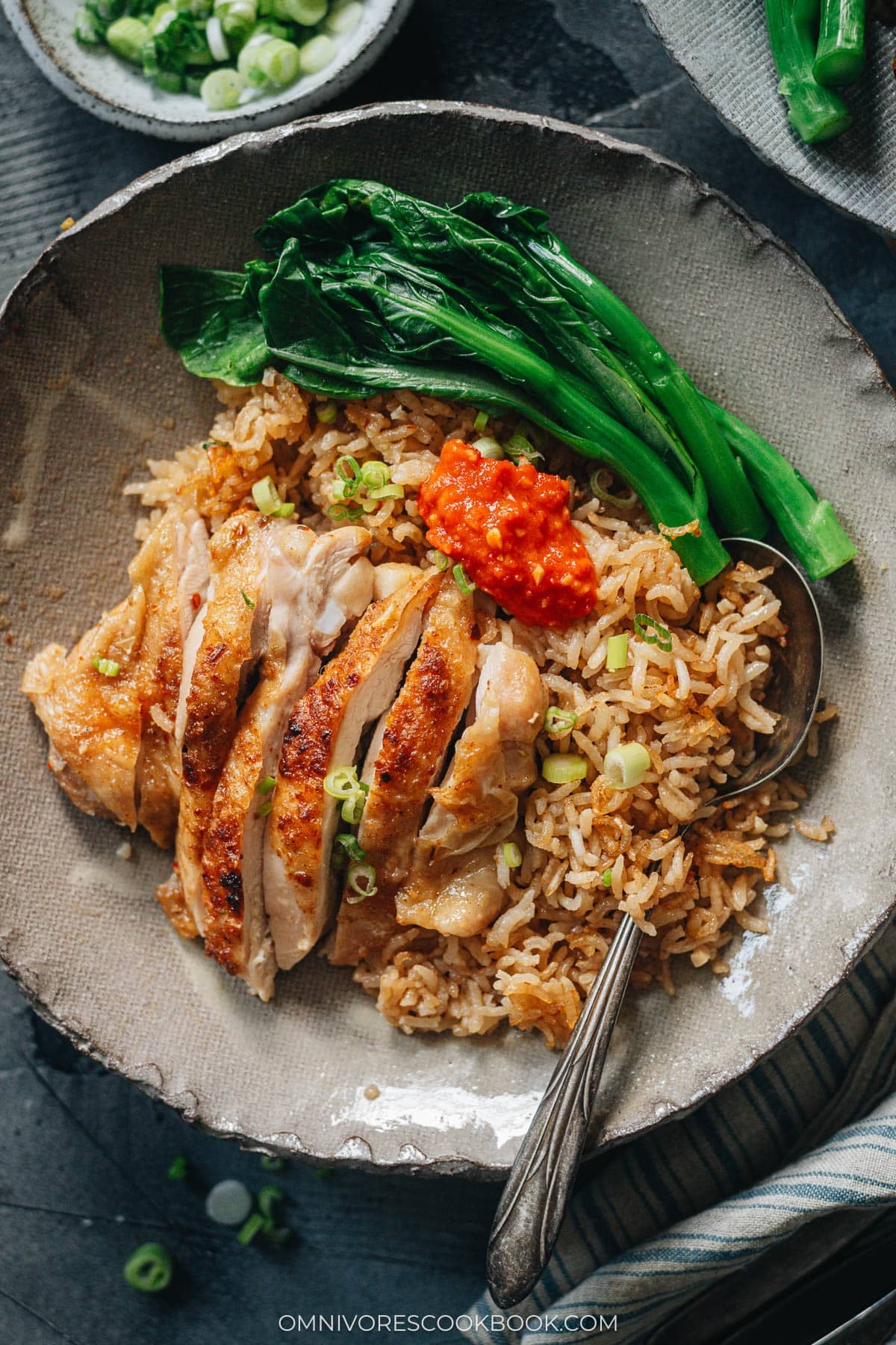 Carved chicken served on rice with Chinese broccoli